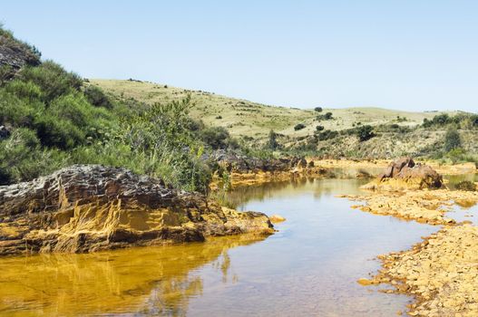 Detail of polluted river by chemicals near an abandoned mine