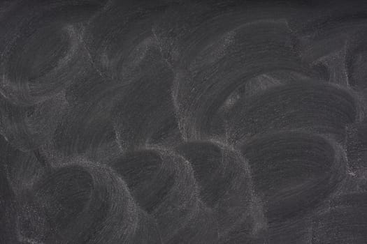 white chalk circular eraser patterns on blank blackboard