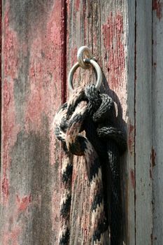 A Horse rope tied to a old red barn