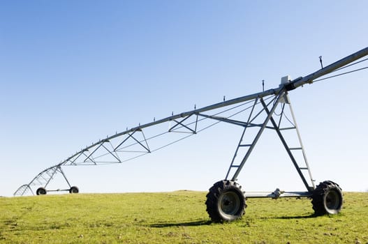 Resting irrigation pivot in a green grass field.