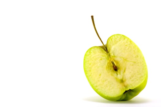 Green apple with stalk cut in half on a white background