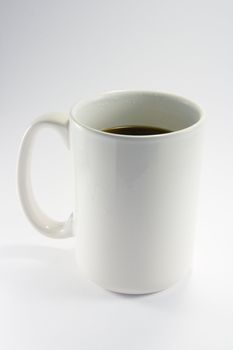 White coffee mug with black coffee on a white background