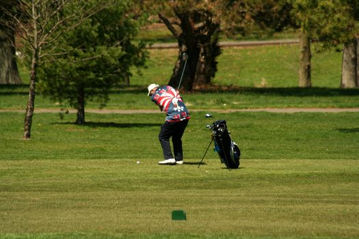 A Male golfer chipping to the green