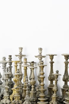 Large group of abandoned candlesticks covered with dust
