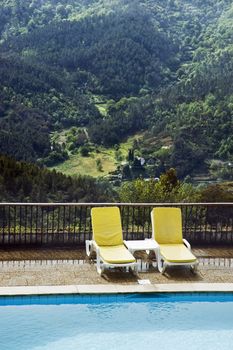 Long chairs by the pool in a mountain landscape