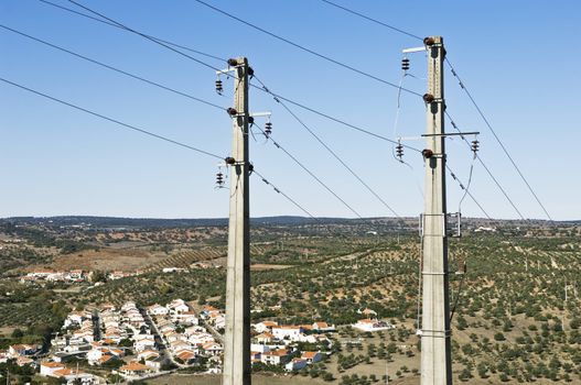 Two concrete electric poles near a small village
