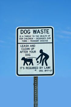A dog waste sing against a blue sky