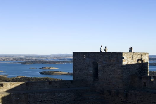 Tourists in a tower of Monsaraz castle enjoing the view over Alqueva reservoir, Alentejo, Portugal