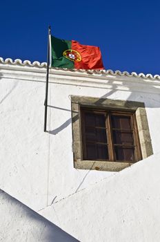 Portuguese flag hoisted in the former Court House of the medieval village of Monsaraz, Alentejo, Portugal