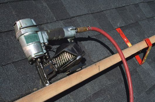 A Pneumatic roofing nail gun with air hose