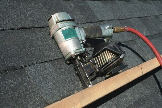 A Pneumatic roofing nail gun with air hose