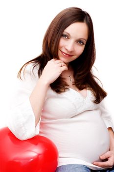 Pregnant woman leaning on heart shaped balloon over white