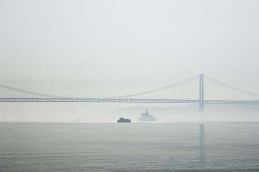 Ferrys crossing the Tagus river near 25th April bridge in a foggy morning