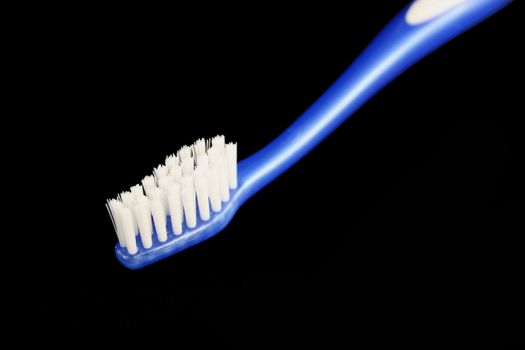 Isolated blue toothbrush on black background