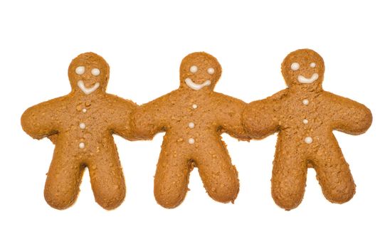 Concept image of friendship by using three gingerbread cookies that are holding hands, isolated against a white background