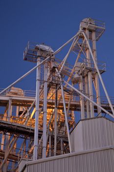 industrial abstract - top of a grain elevator with gravity flow pipes at night