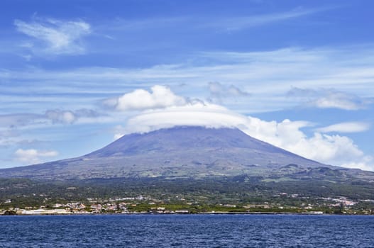 Beautiful cloud formation over Pico volcanic mountain view from the sea, Pico island, Azores, Portugal
