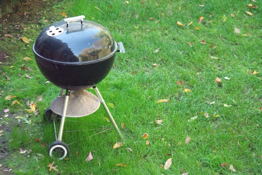 A Black Barbeque grill  in the yard