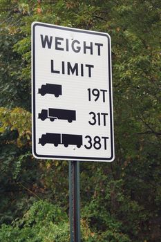 A Truck Weight Limit Sign against trees