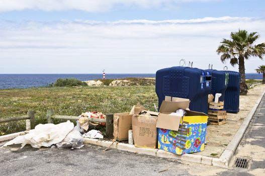 Trash neglectfully abandoned near recycle containers
