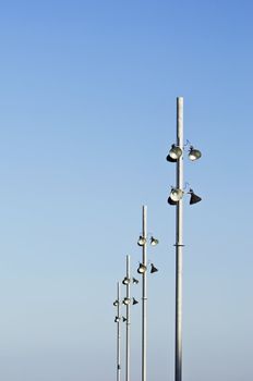 Modern streetlights against a clear blue sky
