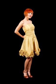 Beautiful Caucasian redhead woman in yellow cocktail dress, isolated