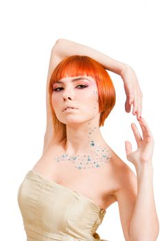 Beautiful redhead Caucasian girl with rhinestones and arms around her head, isolated