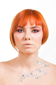 Beautiful face of a redhead Caucasian girl with sea blue eyes and rhinestones, isolated