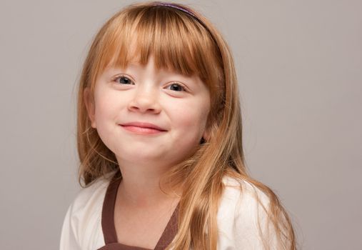 Portrait of an Adorable Red Haired Girl on a Grey Background.