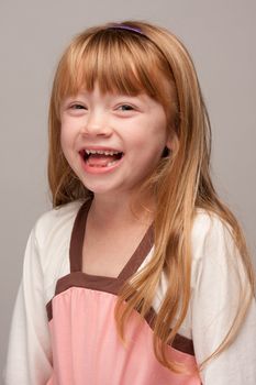 Portrait of an Adorable Red Haired Girl on a Grey Background.