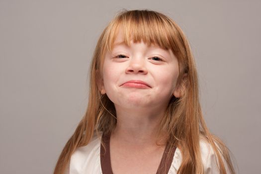 Portrait of an Adorable Red Haired Girl on a Grey Background.