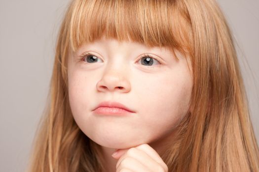 Portrait of an Adorable Red Haired Girl on a Grey Background.