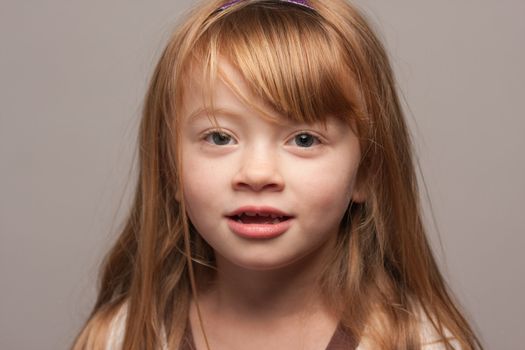 Portrait of an Adorable Red Haired Girl on a Grey Background.