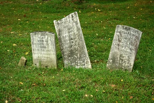 Three Old Gravestone with grass in a graveyard