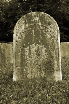 Old Gravestone with grass in a graveyard