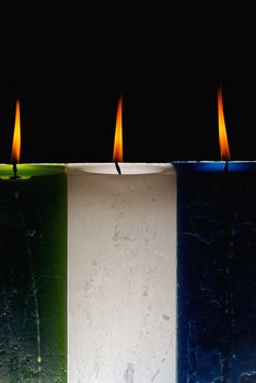 Lit candles of different colors and rectangular shape