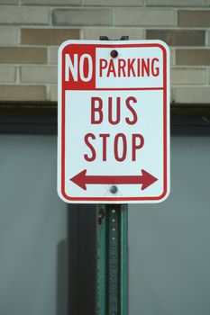 Bus stop and no parking sign outside a school