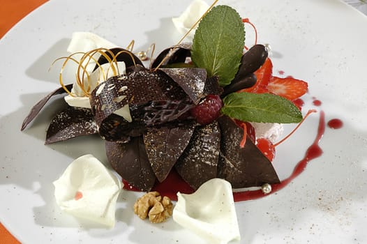 chocolate dessert with a caramel, decorated white petals or rose and mint