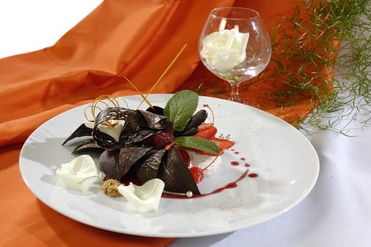 chocolate dessert with a caramel, decorated white petals or rose and mint