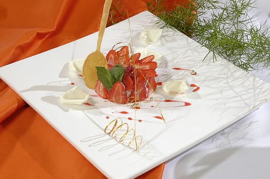 strawberry dessert, decorated white petals of rose, pearls and mint