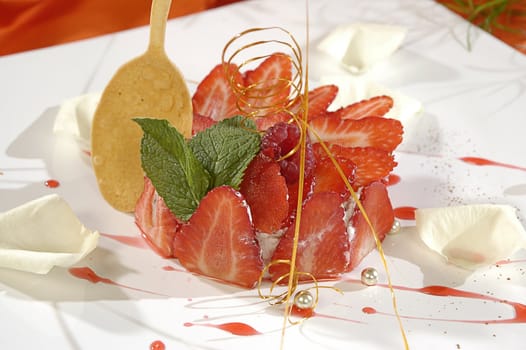 strawberry dessert, decorated white petals of rose, pearls and mint