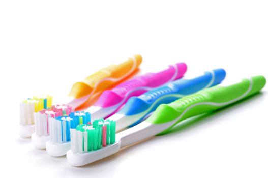 Four very colorful toothbrushes on a white background.