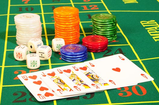 Casino chips,playing bones and royal flash combination on green felt