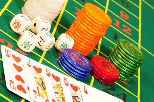 Casino chips,playing bones and royal flash combination on green felt