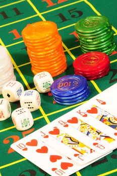 Casino chips,playing bones and royal flash combination on green felt