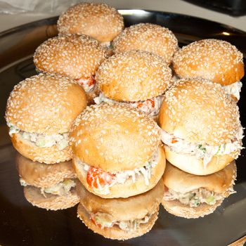 Miniature hamburger buns filled with chicken vegetable salad.