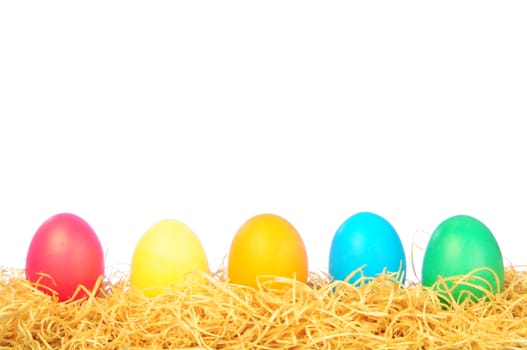 five painted eggs on a straw on a white background