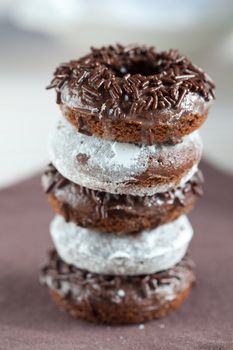 Stack of chocolate doughnuts and sugar covered doughnuts