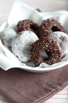 Bowl filled with chocolate doughnuts decorated with chocolate sprinkles