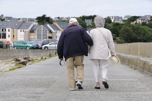 Happy senior couple walking along the coast of brittany